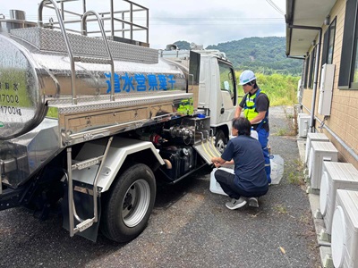 給水車から、住民が水を入れている様子
