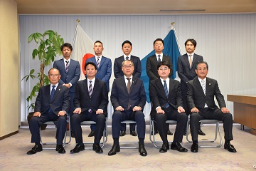 都市対抗野球大会出場チームの皆さんと記念撮影をする信田議長