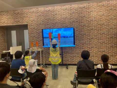 ANAスカイセンターにて飛行機誘導の体験をしている様子