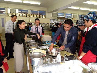 生徒と一緒に調理実習する講師