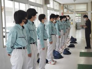 天羽高校の工業基礎コースの写真　作業着を着用した生徒が横に並んでいる