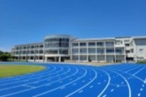 横芝光町立光中学校の校舎と青いグラウンドの写真