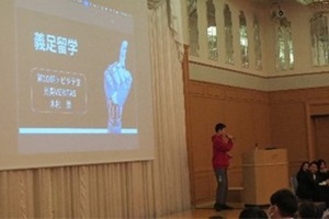 登壇し、パワーボイントを使用して留学体験談を発表する男子生徒の写真
