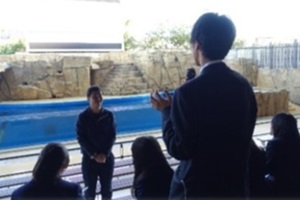 生徒がマイクを使って企業の駐在員に質問している写真