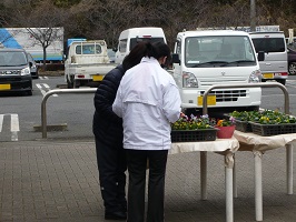 お客さんとお花を選ぶ生徒の画像