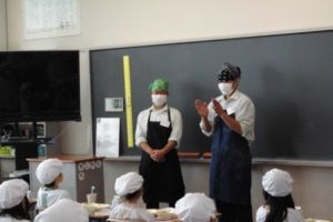 高校生と小学生が給食をいただく写真