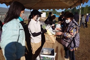 お客様と商品やお金のやり取りをする生徒たちの写真