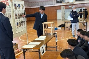 研究成果をまとめたポスターの前で発表する3年生2名と、説明を聞く後輩たちの写真