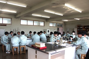 生徒たちが実習室に集まり班ごとに分かれて座っている写真
