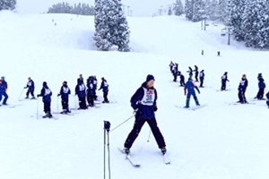 足をハの字に開いて斜面を下る生徒の写真