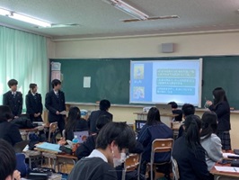 教室でスクリーンを使って発表する生徒たちの写真