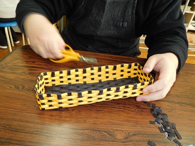 生徒がカトラリーケースのクラフトテープをカットしている様子