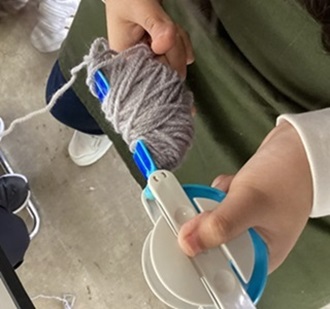 生徒が毛糸をまるめている様子