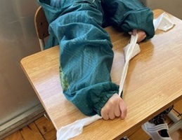 生徒が布を両手で裂いている様子