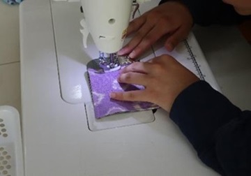 生徒がミシンでコースターを縫っている様子