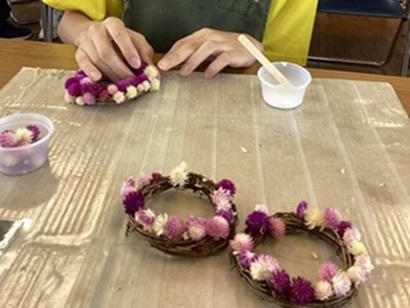 生徒が花を束ねてリースにしている様子