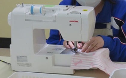 生徒が小物入れをミシンで縫っている様子
