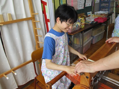 生徒が織り機で布を織っている様子