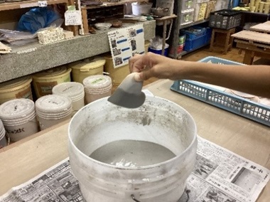 生徒が陶器に釉薬掛けをしている様子