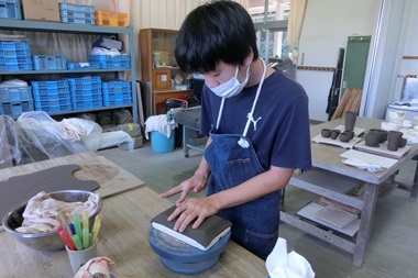 生徒が粘土で皿を制作している様子