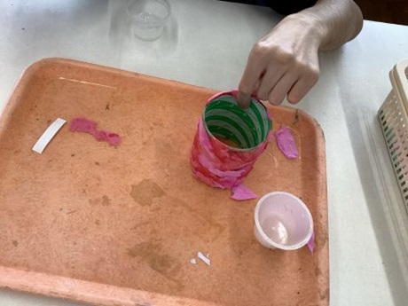 生徒が型に紙を貼り付けている様子