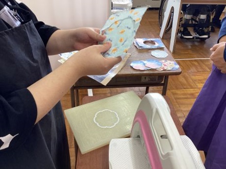 生徒が紙からコースターの型をとっている様子