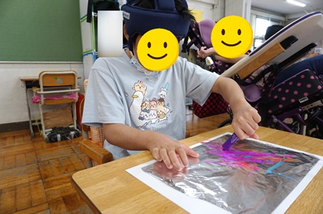 児童がセロファンにマジックで描いている様子
