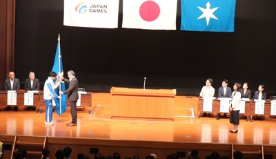 団長から選手代表への団旗授与の画像