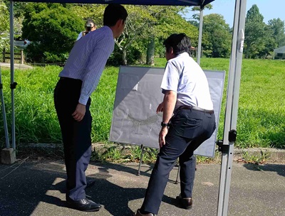旧ひめはるの里跡地における現地視察の際、資料を見ながら市長の説明を聞く知事の画像