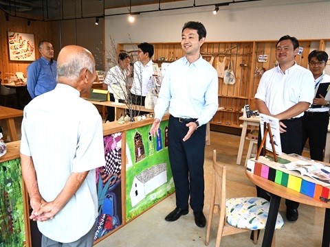 複合商業施設「the Green」における現地視察の際、店舗内で説明を聞く知事の画像
