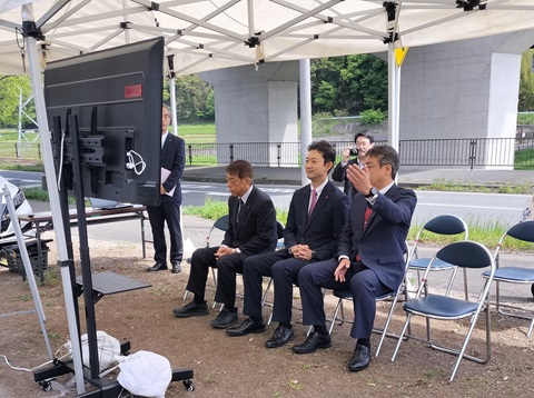 圏央道（仮称）かずさインターチェンジ建設予定地における現地視察の際、資料を見ながら市長の説明を聞く知事の画像