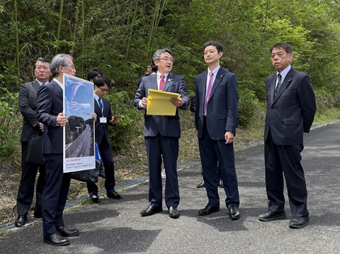 圏央道（仮称）かずさインターチェンジ建設予定地における現地視察の際、資料を見ながら市長の説明を聞く知事の画像