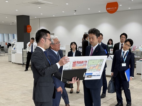 市原市八幡総合市民センター（やわたパレット）における現地視察の際、資料を見ながら市長の説明を聞く知事の画像