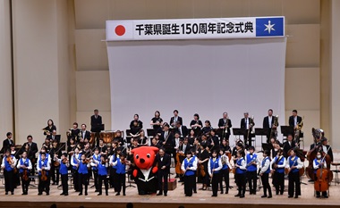 千葉県少年少女オーケストラと千葉交響楽団がチーバくんと舞台上で挨拶をしている様子