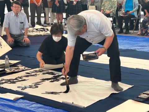 席上揮毫をする写真
