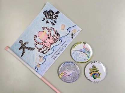 体験イベントの制作物の完成写真。ミニ大漁旗と海の幸の缶バッジが並んでいる。