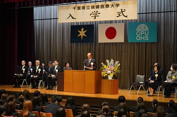 千葉県立保健医療大学講堂においてお祝いの言葉を述べる佐野議長の様子
