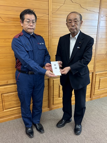 熊本県田口東京事務所長(左)に見舞金を贈呈する宍倉議長(右)