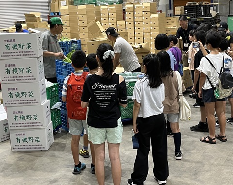 市場の野菜コーナーを見学する子どもたちの画像