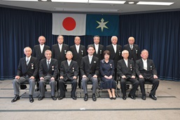 秋の叙勲伝達式のスーツの男性が多めの集合写真