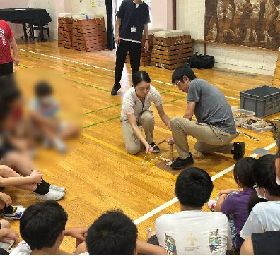 火おこしの説明と実演の様子の写真