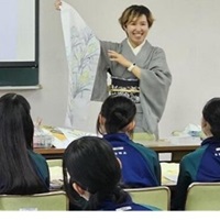 講師が友禅染の実物を見せて、製作方法や文化や歴史について生徒に説明する写真