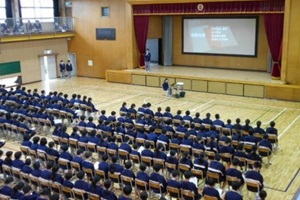 市川市立妙典中学校の新入生オリエンテーションで、体育館に生徒が集合して座っている写真