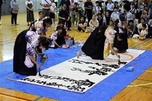 中高合同文化祭で生徒が書道パフォーマンスを披露している写真