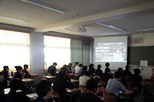 教室のスクリーンを見ている生徒たちの後姿の写真