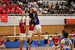 バレーボールの男子決勝戦の試合中、アタックを狙いジャンプする選手の写真