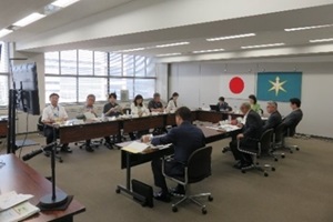 囲み机に座り意見交換を行う教育長と委員たちの写真