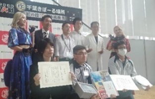 表彰式で賞状を持ち笑顔を見せる生徒たちの写真