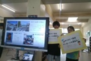 児童2名が感謝の言葉が書かれたパネルを持って立っている写真