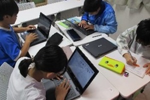 パソコンを使って調べものをする児童たちの写真
